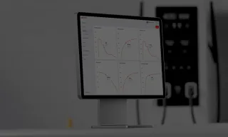 Computer monitor displaying an asset management dashboard. An A400 charger can be seen in the background.