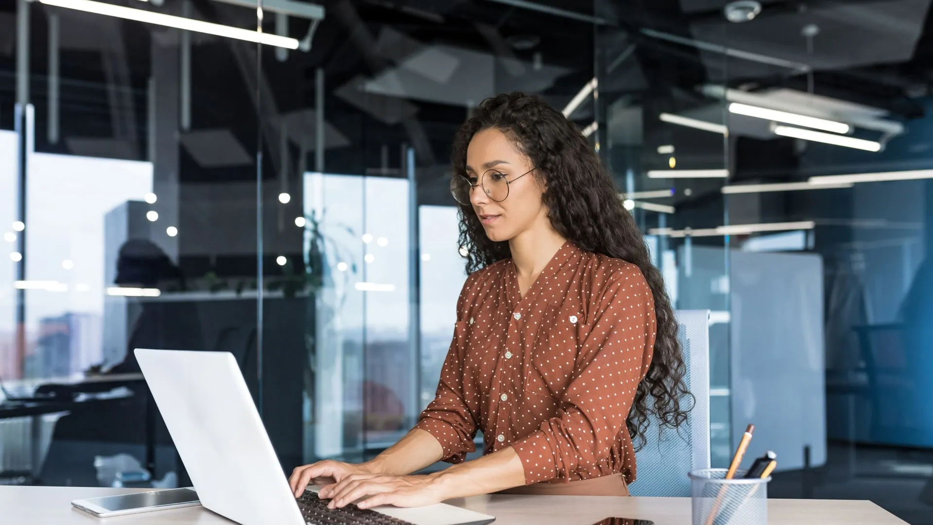A woman is sitting on a desk with a notebook