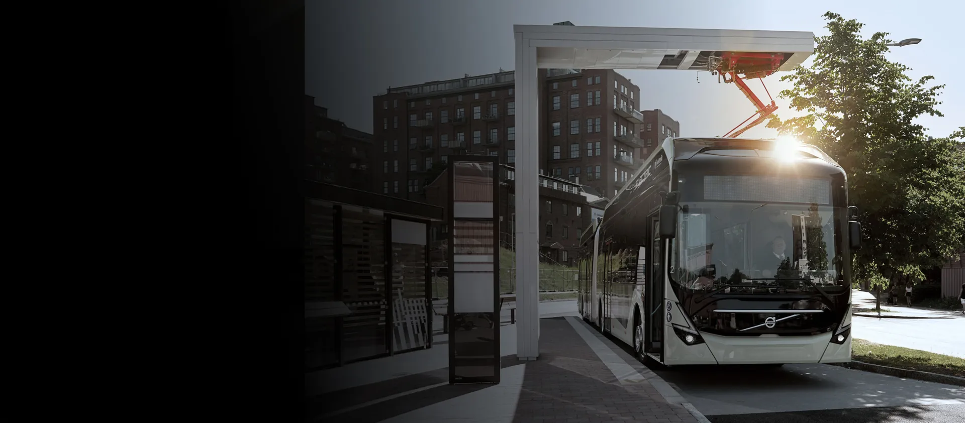 A bus charges at a stop on route using a pantograph down system
