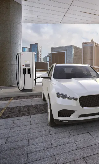 An electric vehicle is charging at a T184 charger in a cityscape