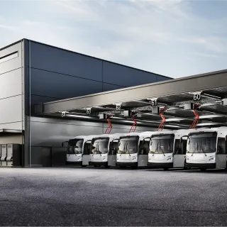 A fleet of buses charge using panto-down systems in a bus depot